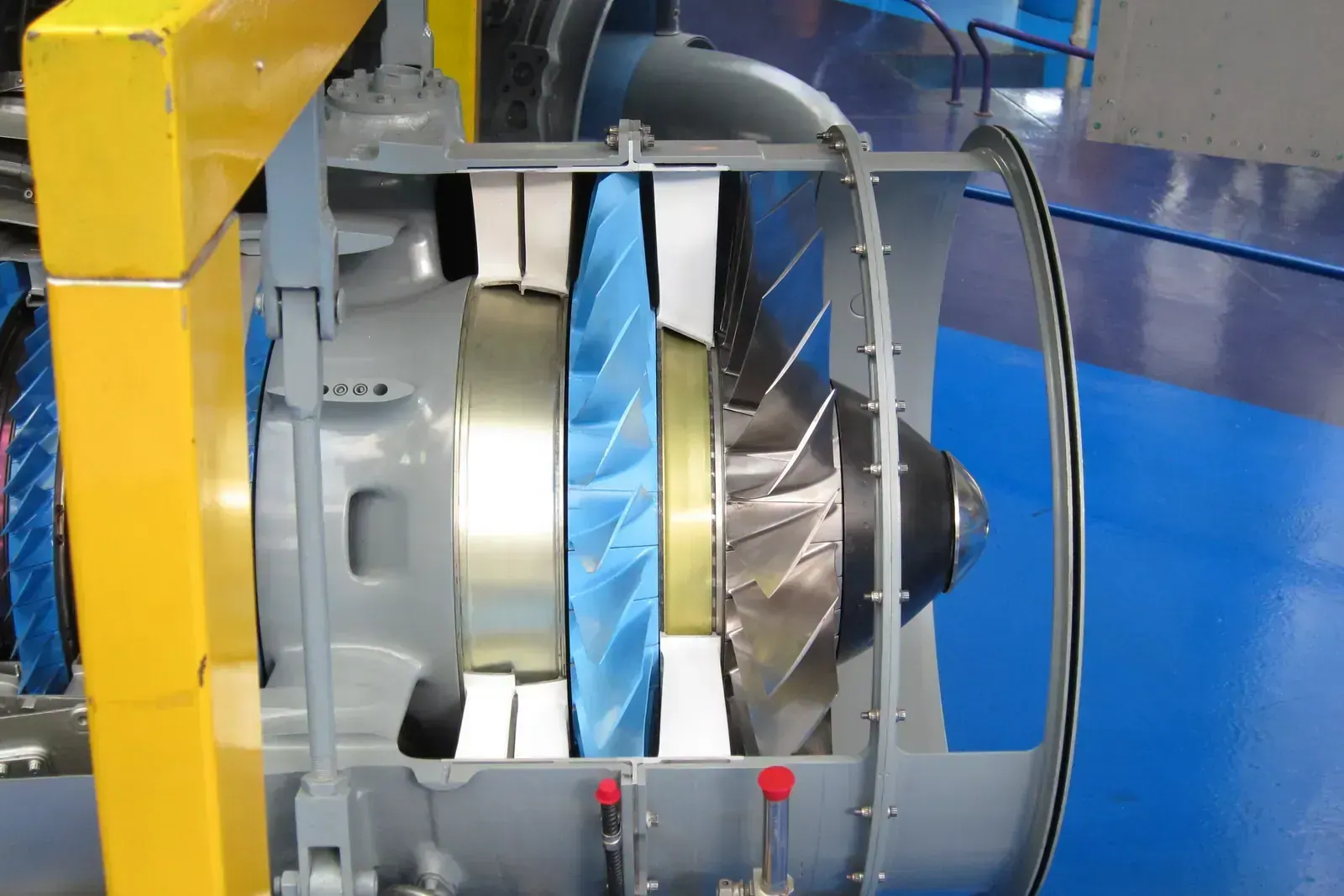 A sectioned Rolls-Royce Turboméca Adour turbofan seen head-on, its machined intake ring and fan blades exposed.